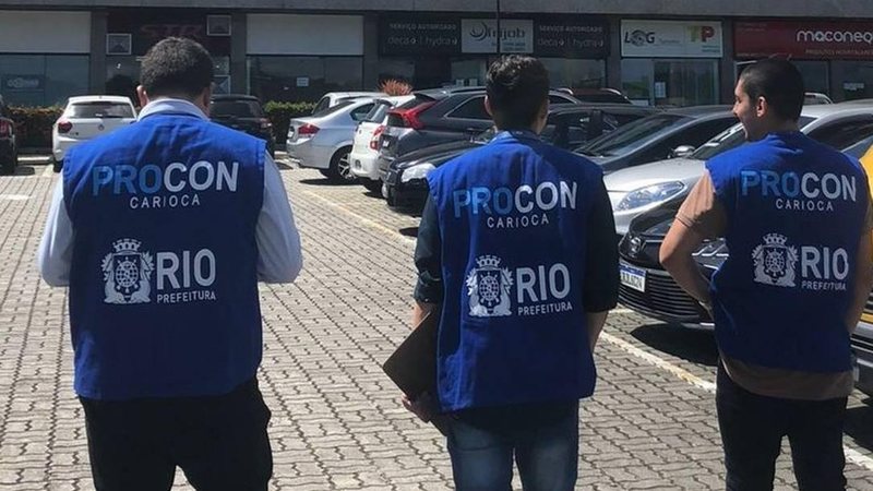 Procon Carioca aguarda pela resposta das empresaas Procon Rio Três homens de costas com coletes 'Procon Rio' - Divulgação