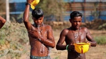 Cientistas acreditam que a nova onda de calor se deve ao fato de mudanças climáticas mundiais Forte calor na Índia Dois meninos se molhando com baldes de água na Índia - Divulgação