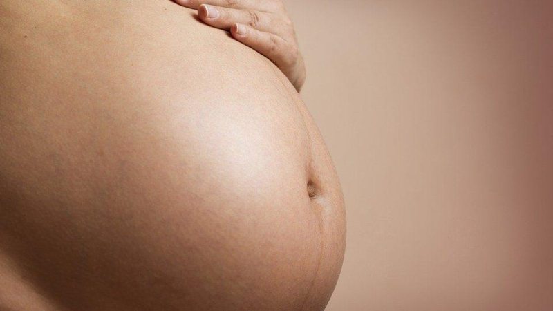 Mulher de 24 anos estava grávida de gêmeos; um deles foi encontrado no lixo Barriga de mulher grávida Mulher com a mão na barriga de grávida - Imagem ilustrativa