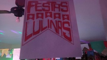 Festa Lulina com junção da comemoração junina e do apoio ao pré-candidato Lula Festa Lulina Bandeira rosa com a escrita em vermelho: Festas Lulinas - Arquivo Pessoal