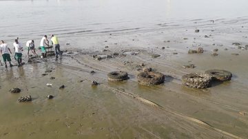 Muitos dos penus estavam enterrados na areia, o que exigiu esforço manual para levantá-los Até pneu de trator é encontrado durante maré baixa em Santos Equipe retira pneus em faixa de areia exposta pela maré baixa na Ponta da Praia, em Santos - Prefeitura de Santos