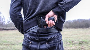 Baixada Santista possui cinco clubes de tiro, três deles estão em Praia Grande, onde há 1.277 registros ativos Armas na Baixada Santista Homem de costas vestindo suéter e calça jeans escuros segurança uma arma preta presa em seu cóccix - Pixabay