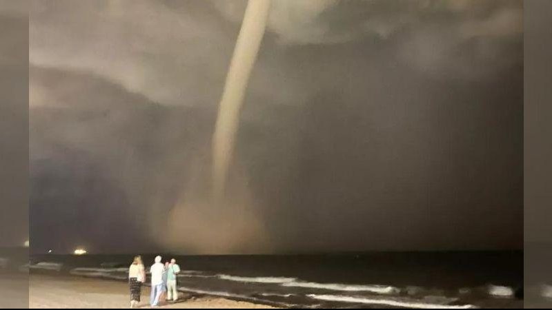 Fenômeno aconteceu em Prat de Llobregat, cidade próxima a Barcelona, na sexta-feira (16) Vídeo mostra imensa tromba d’água em praia da Espanha Pessoas assistem da praia, durante a noite, tromba d'água sobre o mar, na Espanha - Reprodução/Redes Sociais/MetSul