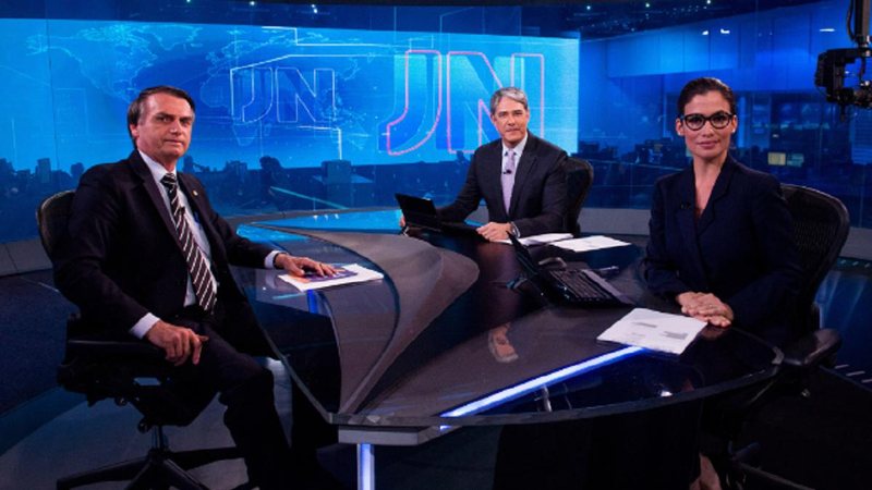 Jair Bolsonaro (PL) é o primeiro candidato entre os presidenciáveis a ser entrevistado pelo jornal Jornal Nacional Dois homens e uma mulher sentados em um programa de TV - jornal - Reprodução