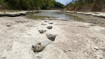 Dinos deram "rolês" pelo parque americano há 113 milhões de anos Pegadas de dinossauro de 113 milhões de anos são reveladas nos EUA Pegadas de dinossauro em leito seco de um rio no Texas, nos EUA - Reprodução/DINOSAUR VALLEY STATE PARK/AFP/METSUL METEOROLOGIA