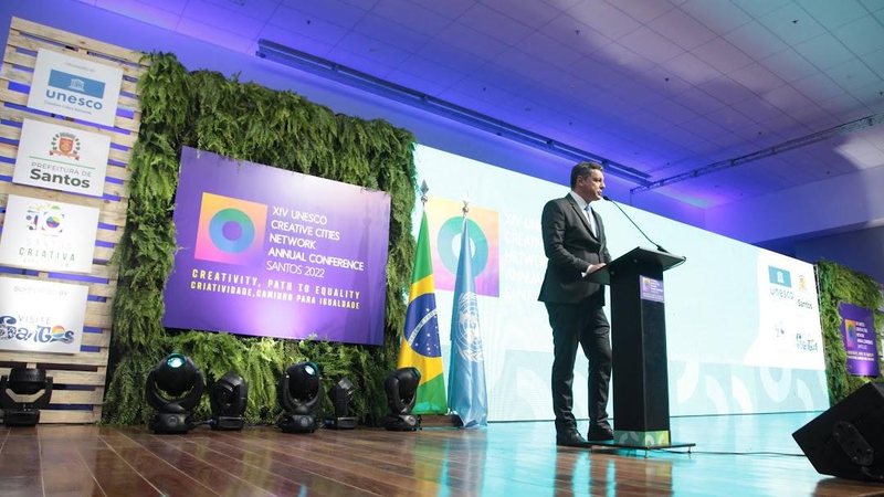 Prefeito de Santos, Rogério Santos, durante discurso de encerramento Santos: Conferência das Cidades Criativas da Unesco termina com compromisso contra a desigualdade Prefeito de Santos, Rogério Santos, em palco fazendo discurso - Imagem: Divulgação / Isabela Carrari / Prefeitura de Santos