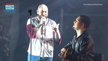 Theo Kant é morador de Niterói (RJ) e conseguiu ficar na grade do show para mostrar seu cartaz e ter a oportunidade de subir ao palco Post Malone Post Malone, rapper careca e com um microfone nas mãos com o fã tocando violão no palco - Reprodução