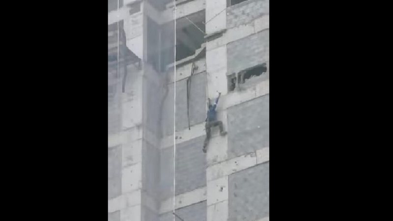 Homem ficou pendurado por meio de uma corda depois do cabo de segurança romper Trabalhador pendurado em obra Homem pendurado em uma corda em obra de um prédio de Guarujá (SP) - Reprodução