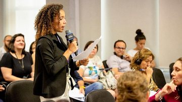Com outras psicólogas, Larissa (em destaque) participa de projeto que atende brasileiros longe de casa Capa - Psicóloga de Bertioga atende brasileiros no mundo inteiro Mulher dando palestra - Imagem: Acervo Pessoal / Larissa Pires