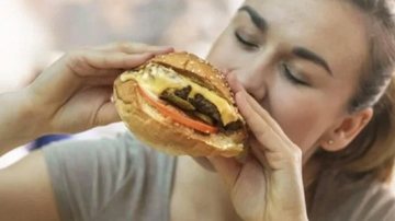Mulher foi indenizada com R$ 10 mil por danos morais Hamburguer Mulher comendo hambúrguer - Divulgação