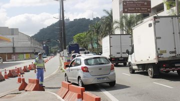 A faixa reversível funciona das 7h às 9h Faixa adicional de trânsito volta a ser ativada na entrada de Santos na segunda-feira (16) Agentes da CET-Santos orientam trânsito na entrada da cidade - Prefeitura de Santos