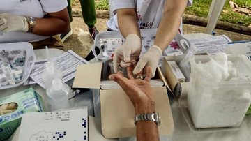 Haverá diversas ações nas policlínicas no decorrer do mês de novembro Santos intensifica ações de saúde no mês da Consciência Negra Enfermeiras fazem exame de glicemia em paciente do sexo masculino - Prefeitura de Santos