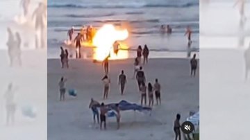 Banhistas tentam apagar as chamas com a água do mar FOGO NO CARRINHO DE MILHO Pessoas tentam apagar o fogo em um carrinho de milho, na faixa de areia - PRAIA GRANDE MIL GRAU