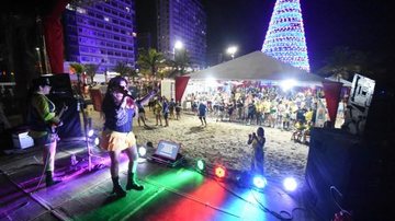 Praia Grande tem ao todo seis arenas de entretenimento, cultura e esporte Estação Verão em PG Mulher cantando com um jogo de luzes no palco na praia de PG - Divulgação