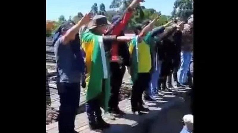 No Brasil, o ato é considerado crime, de acordo com o Artigo 20 da Lei do Racismo Saudação nazista Pessoas com roupas verde e amarelo e braços estendidos em saudação nazista - Reprodução