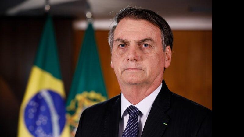 Jair Bolsonaro (PL) já foi deputado federal pelo Rio de Janeiro e foi eleito para seu segundo mandato como presidente da República Jair Bolsonaro Homem sério olhando para a câmera com traje social e bandeira do Brasil atrás - Divulgação