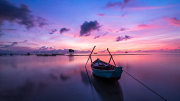 Notícias - 17.10.2022 Barco no mar sob céu púrpura - Copyright: Quang Le / Pixabay