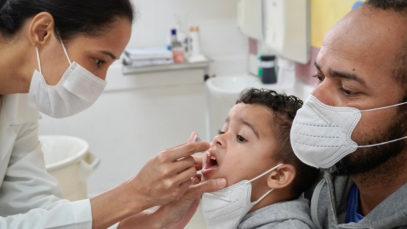 Familiares devem levar a caderneta de vacinação da criança para que profissionais de saúde avaliem se há vacinas que não foram administradas ou doses que necessitam ser aplicadas para completar o esquema vacinal do jovem Criança tomando vacina Profissional - Divulgação