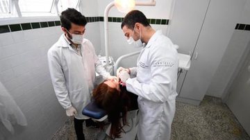 Usafas realizaram a avaliação de cerca de 650 pacientes com atenção especial aos homens acima de 40 anos Saúde bucal Dois dentistas cuidando da boca de uma mulher - Reprodução