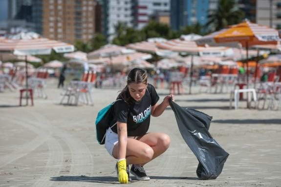 Concentração do evento acontece às 9 horas, em frente a Avenida dos Sindicatos, no Bairro Mirim, em Praia Grande Mutirão de limpeza Jovem catando sujeiras da areia com uma sacola de lixo em uma das mãos - Divulgação