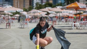 Concentração do evento acontece às 9 horas, em frente a Avenida dos Sindicatos, no Bairro Mirim, em Praia Grande Mutirão de limpeza Jovem catando sujeiras da areia com uma sacola de lixo em uma das mãos - Divulgação