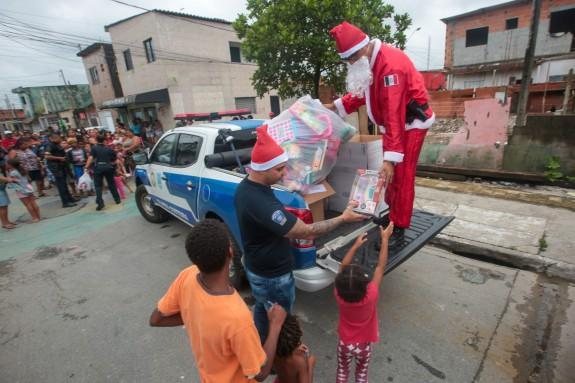 Entregas aconteceram em comunidades carentes do município de Praia Grande Papai Noel Papai Noel em cima de uma viatura da GCM entregando presentes para crianças - Divulgação