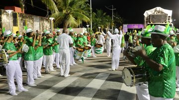 As comemorações começam às 18h30 com a apresentação da Velha Guarda da escola e, às 21 horas Escola de Samba Mocidade Amazonense Pessoas vestidas de verde e branco na rua a noite comemorando o Carnaval - Prefeitura de Guarujá