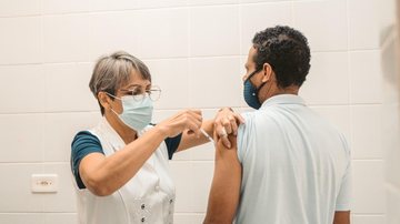Público que poderá se vacinar contra covid-19 deve ter acima de 3 anos Vacinação Enfermeira aplicando vacina em um homem - Divulgação/Prefeitura de Bertioga