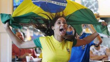 A prefeitura montará um telão no Anfiteatro São Sebastião transmitirá jogos da seleção brasileira em telão montado na rua da praia Torcedora comemorando segurando uma bandeira do Brasil - Foto: AP Photo/Michael Dwyer/Imagem ilustrativa