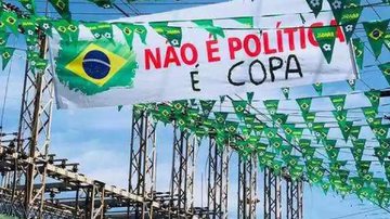 Copa do Mundo de 2022 será em Catar, na Ásia, de 20 de novembro a 18 de dezembro Rua enfeitada - Copa Rua enfeitada com bandeiras do Brasil e faixa com a frase 'Não é política, é Copa' - Reprodução