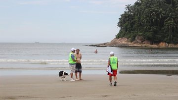 O trecho da praia liberado para cães compreende o espaço entre o posto 1 de salvamento e o Emissário Submarino Santos: operação orienta sobre presença de cães e descarte de lixo nas praias Pessoa com cachorro sendo orientada na praia do José Menino, em San - Prefeitura de Santos