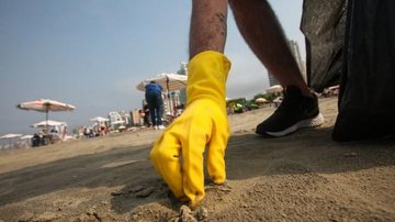 Equipes foram divididas em três para o recolhimento do lixo do 'feriadão' (Proclamação da República) Lixo recolhido da praia Lixo sendo recolhido da praia - Reprodução