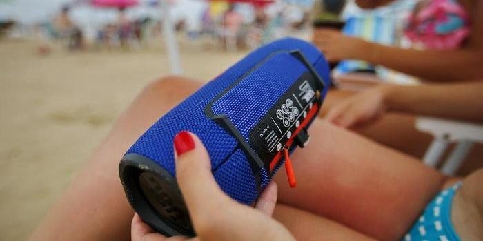 Você é #TeamSomdoMar ou #TeamMúsicaAlta? Carnaval 2023: posso usar caixas de som nas praias? Mulher segurando caixa de som portátil em praia - Félix Zucco/RBS