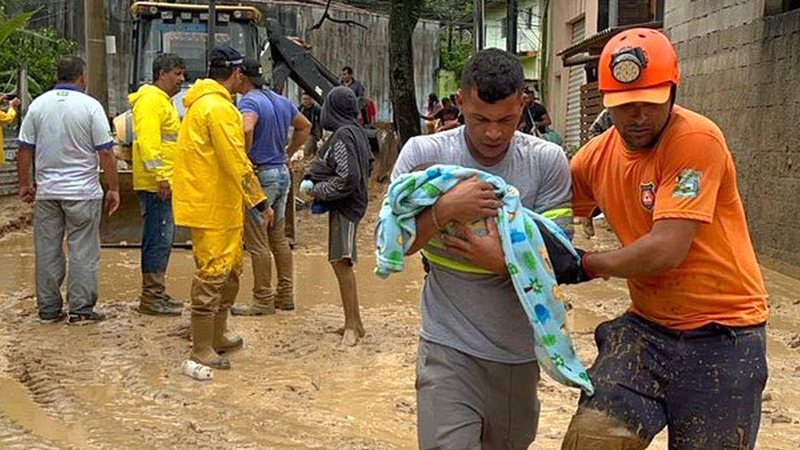 Tragédia provocou a morte de 65 pessoas em fevereiro Pesquisa aponta que população culpa prefeituras pela tragédia no Litoral Norte de SP Homem carrega bebê com apoio de agente da Defesa Civil em meio a tragédia das chuvas em São Sebastião - Prefeitura de São Sebastião