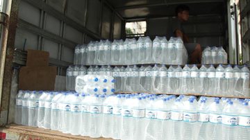 Todos os itens, que foram arrecadados com a população praia-grandenses foram doados para famílias que foram seriamente afetadas pelas fortes chuvas dos últimos dias Água Garrafas d'água empilhadas dentro de um caminhão - Divulgação