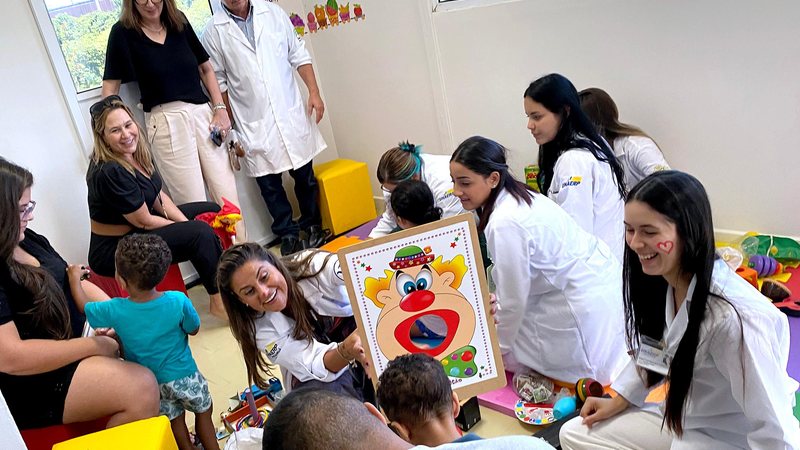 Voluntários da Unaerp, alunos e professores da Universidade, fazem a interação com a garotada  Voluntários brincando com as crianças - Divulgação/Unaerp