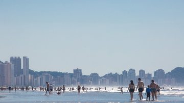 Praia Grande está com seis praias com bandeira vermelha, segundo a Cetesb Bandeira vermelha: Baixada Santista tem 11 praias impróprias para banho Pessoas caminhando à beira-mar em Praia Grande, em dia ensolarado - Prefeitura de Praia Grande