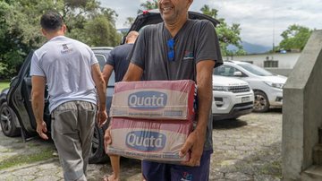 Doações de alimentos não perecíveis, roupas, colchões e itens diversos estão sendo entregues pelo Fundo Social de Solidariedade Prefeitura de Bertioga autoriza que desabrigados voltem para casa Homem carregando caixas de leite de doação - Divulgação/Prefeitura de Bertioga