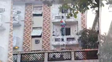 Momento em que mulher é retirada do apartamento em chamas pelos bombeiros Mulher é resgatada de apartamento em chamas em Santos | VÍDEO - Reprodução
