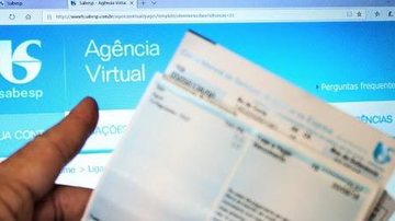 Mutirão é voltado para imóveis residenciais, comerciais e industriais que tenham contas em aberto com a Sabesp Sabesp inicia mutirão de negociação de dívidas a partir de segunda (31) Pessoa em frente ao computador com página da Agência Virtual da Sabesp e  - Reprodução