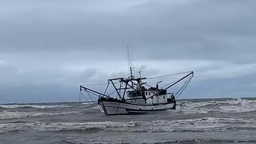 Quatro tripulantes foram resgatados da embarcação Flagrante: barco de pesca encalha no litoral sul de SP Barco encalhado em Ilha Comprida - Reprodução/Vídeo de Fabiana Guarnieri