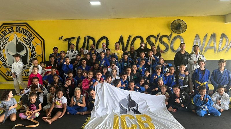 Charles do Bronx (ao centro) e crianças atendidas no instituto que leva seu nome Capa - Charles do Bronx participa de treinão de jiu-jitsu em Guarujá Atleta e várias crianças em tatame de jiu-jitsu - Imagem: Divulgação / Vandro Prado / ICBronx