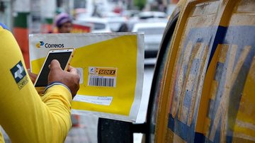 Cada rua da área urbana de Peruíbe terá um CEP específico Peruíbe conta agora com novos CEPs Carteiro conferindo envelope dos Correios - Reprodução/Senado Notícias