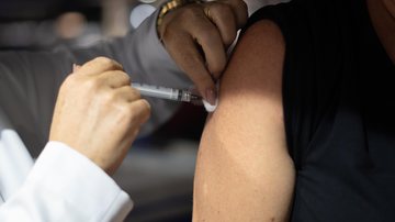 Vacinações contra a gripe e Covid-19 em Bertioga, SP  Pessoa sendo vacinada em iniciativa para assegurar a saúde da população. - Joanderson Santos
