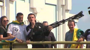 Bolsonaro, em trio elétrico em Rio Branco, simulando uma metralhadora com um tripé de câmara de televisão - Reprodução Youtube