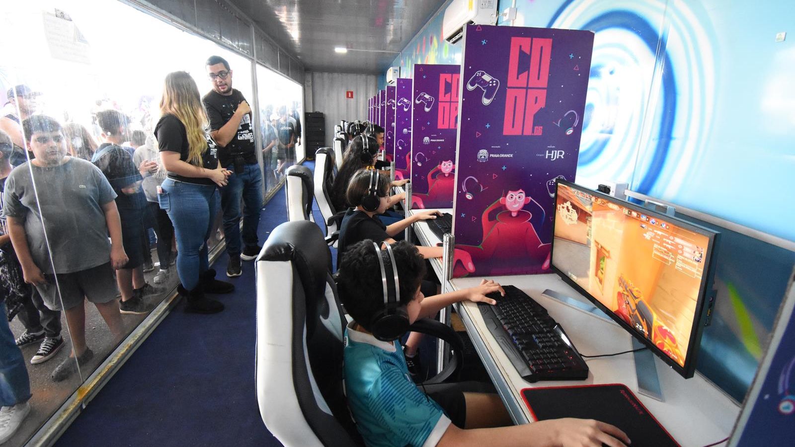 Crianças jogando em computadores em edição do Praia Games
