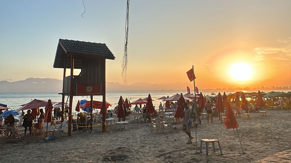 Prainha no fim de tarde e muitas turistas ainda na praia