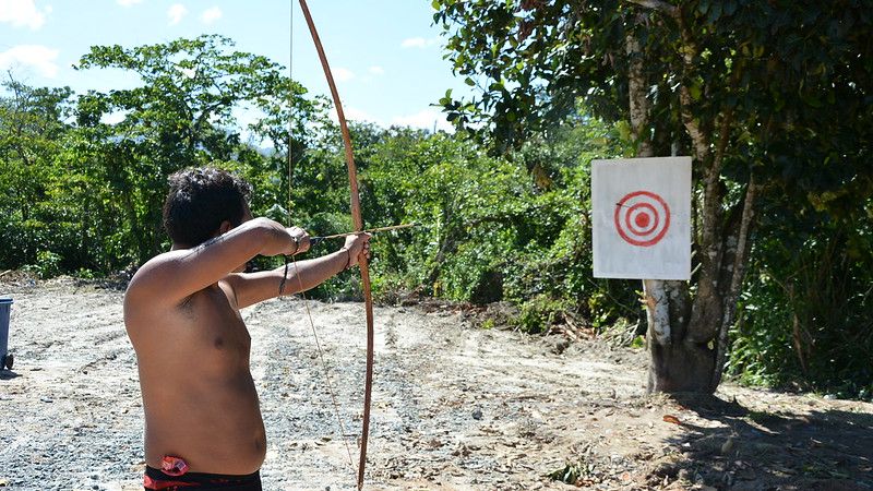 Indígena atirando com arco e flecha
