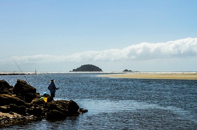 Imagem de um pescador a beira mar