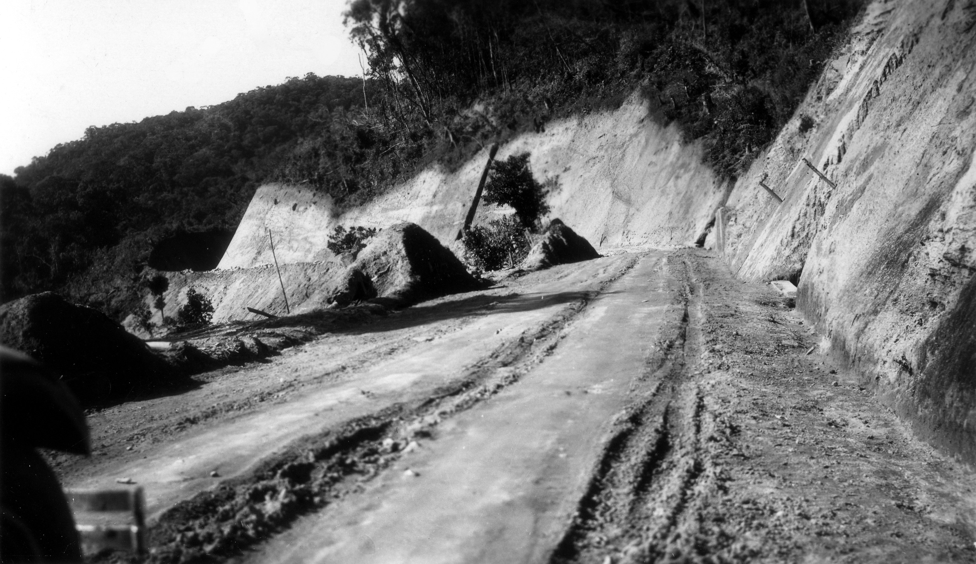 Imagem em preto e branco da rodovia dos Tamoios sem asfalto, apenas em terra